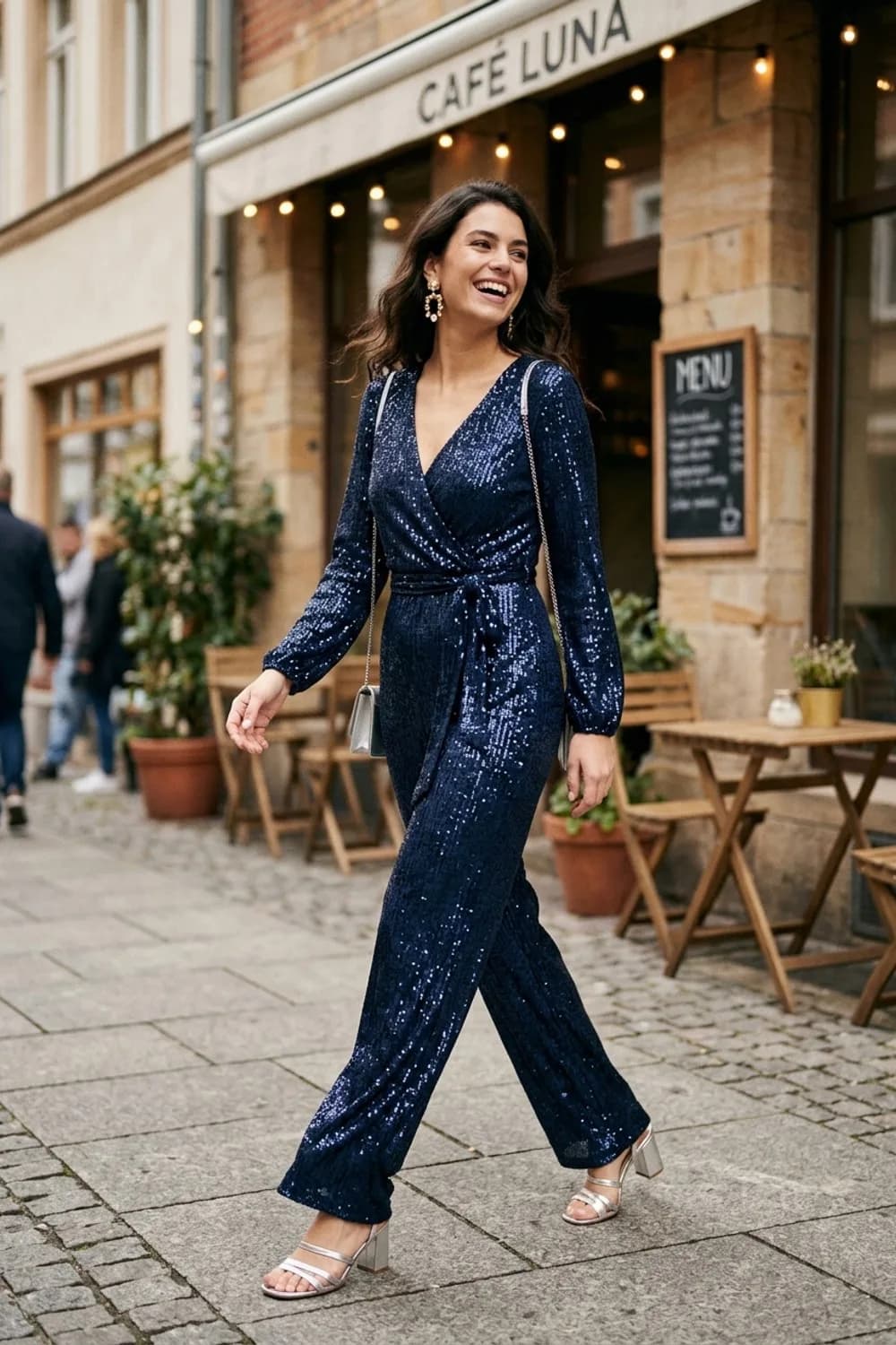 Der All-in-One-Look: Dunkelblauer Pailletten-Jumpsuit, Metallic-Sandaletten und Statement-Ohrringe – Silvester Outfits mit Glitzer: 9 glamouröse Looks für den Jahreswechsel