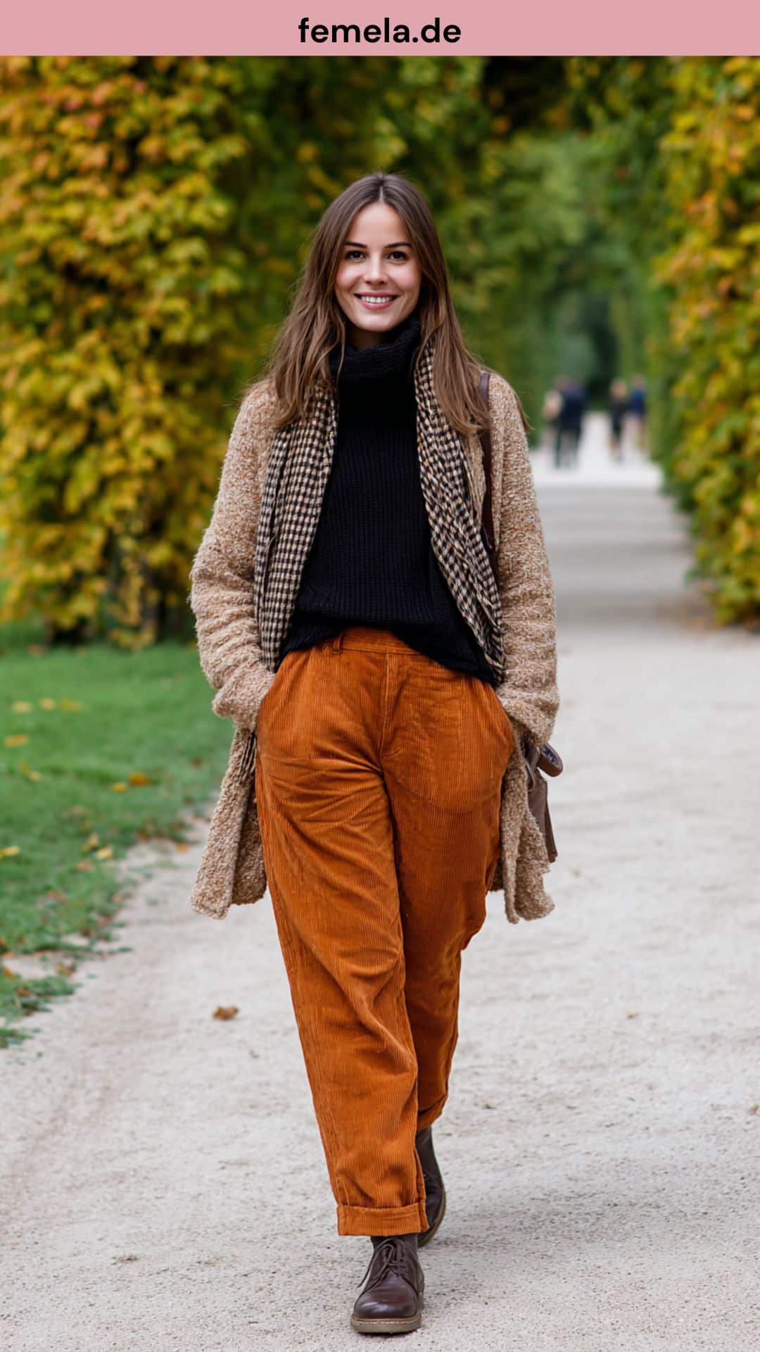 Eine Frau in einem gemütlichen Herbst-Outfit: Sie trägt eine braune Cordhose mit einem beigen Oversize-Pullover, schwarzem Rollkragen und Chelsea Boots.