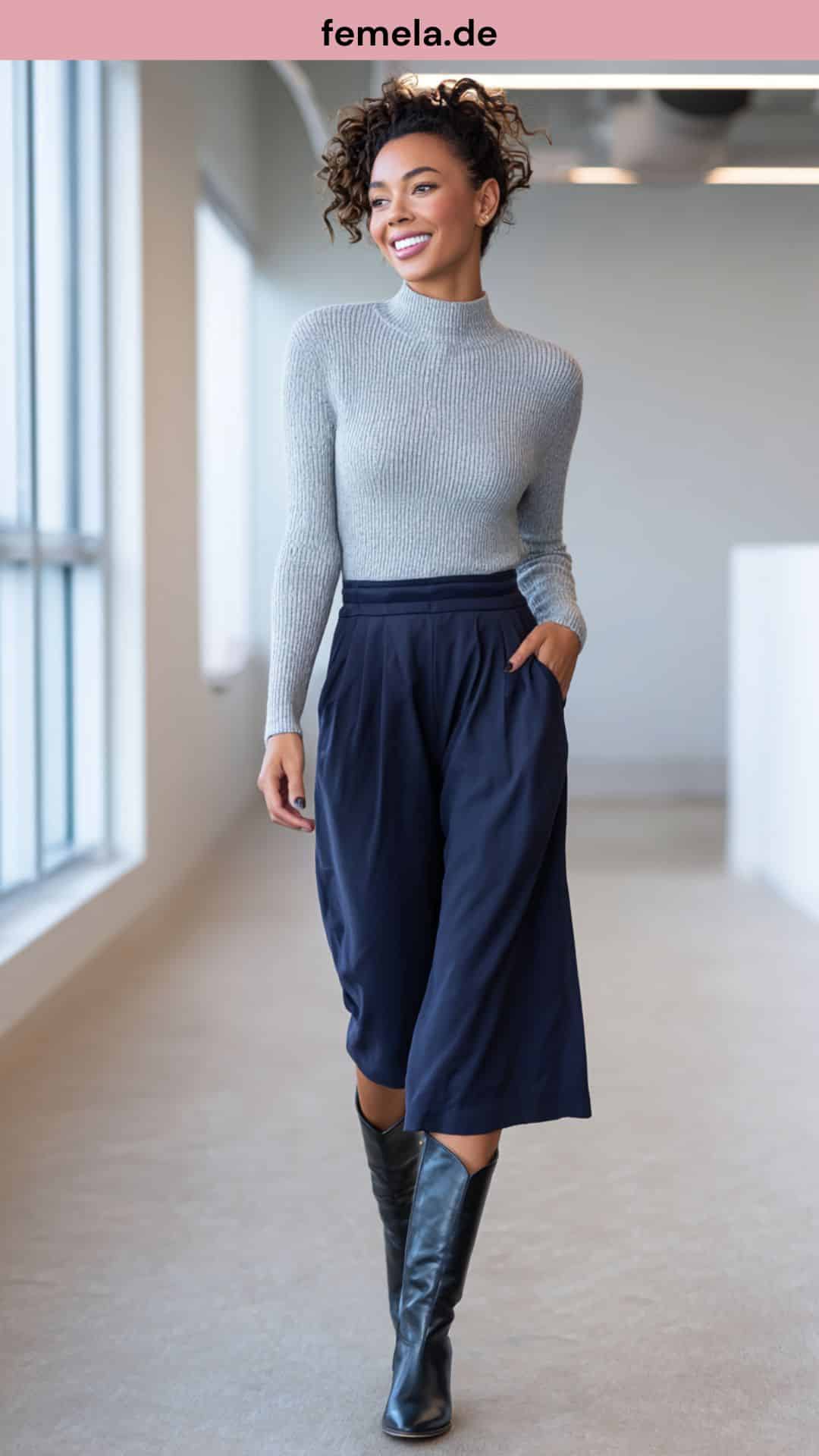 Frau trägt dunkelblaue Culotte mit hohen Stiefeln im Büro