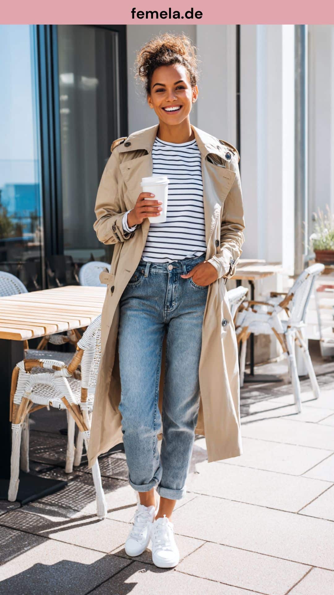 Frau trägt Mom-Jeans, Streifenshirt und weiße Sneaker beim Stadtbummel im Frühling.