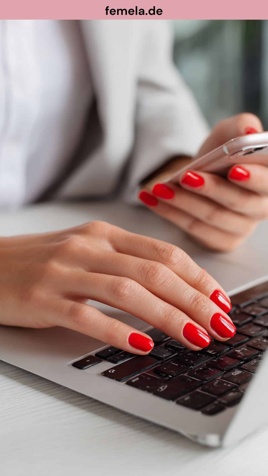 Klassische rote Nägel an einer Laptoptastatur.