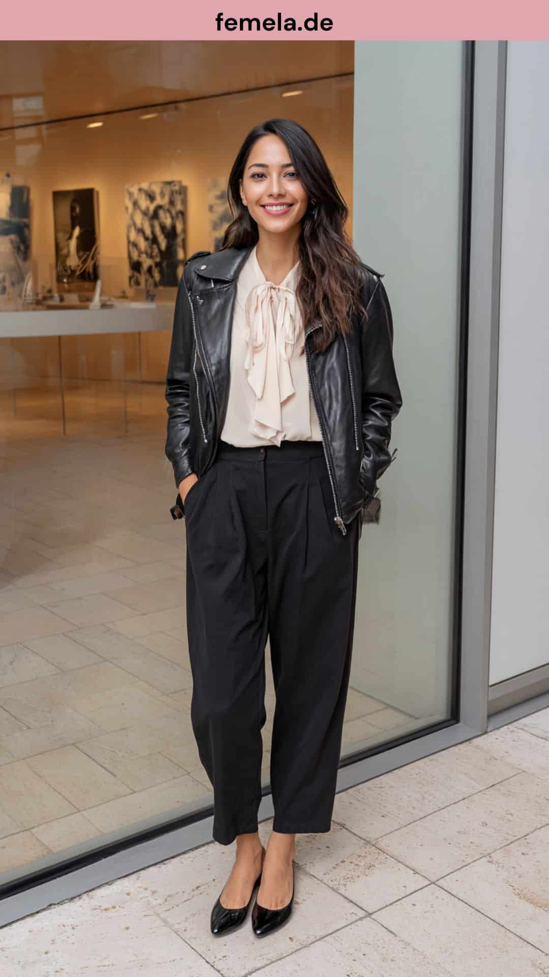 Modischer Stilbruch: Schwarze Lederjacke kombiniert mit einer pastellfarbenen Schluppenbluse und Stoffhose.