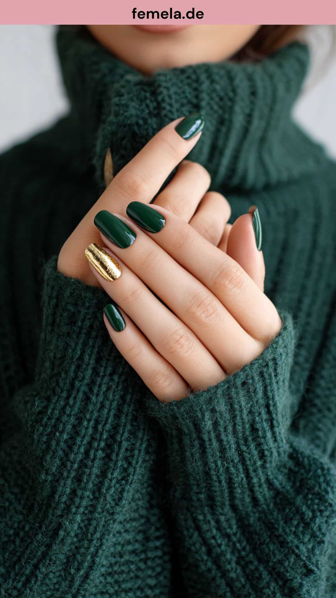 Nahaufnahme von matten grünen Nägeln mit Goldakzent auf Strickpullover.