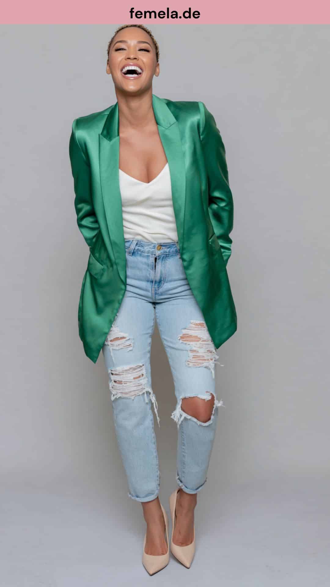 Kontrastreiches Jeans Party Outfit mit grünem Satin-Blazer und lässiger destroyed Jeans.