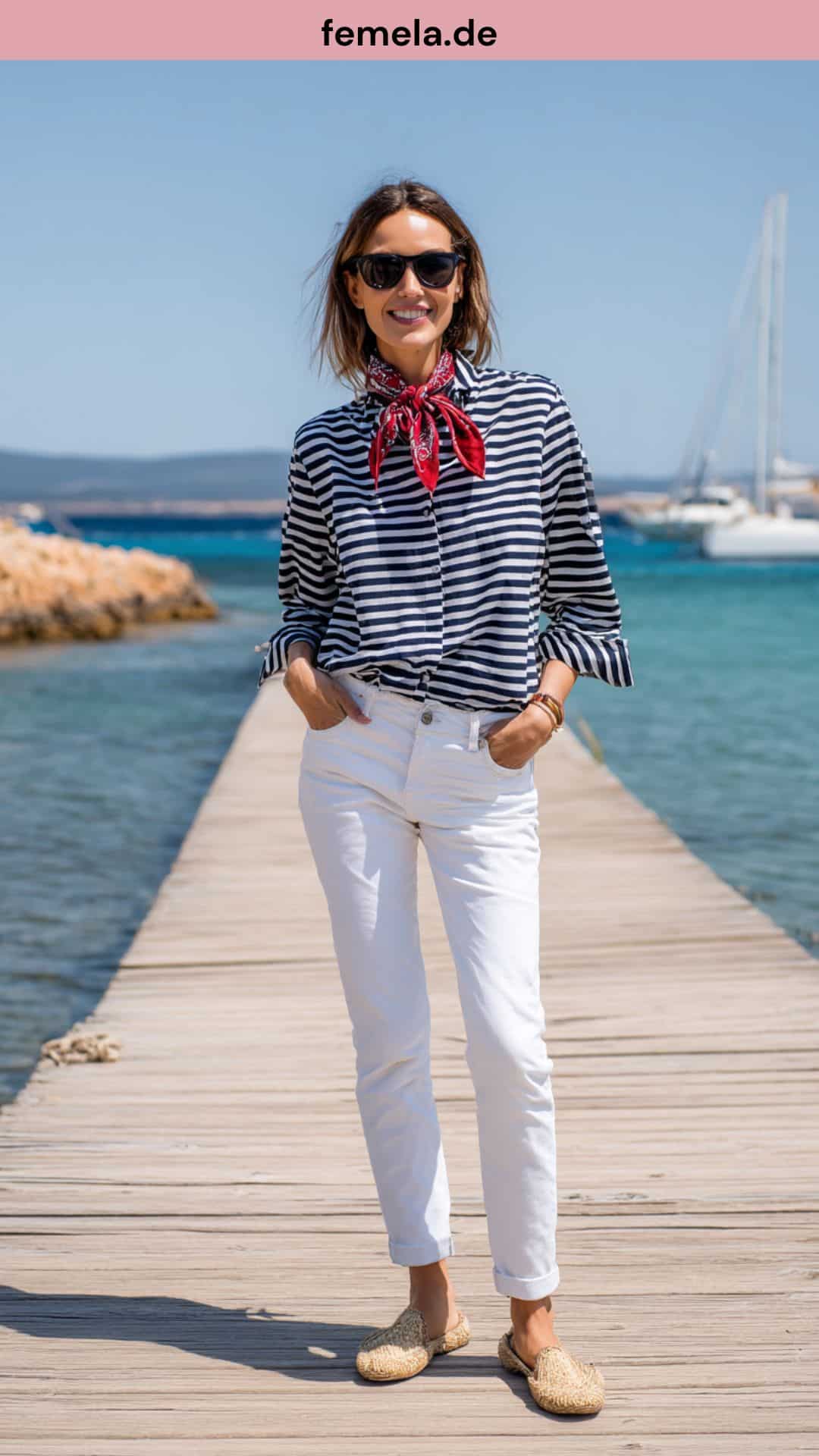 Maritimer Sommerlook mit weißer Jeans, Streifenshirt und roten Accessoires am Meer.