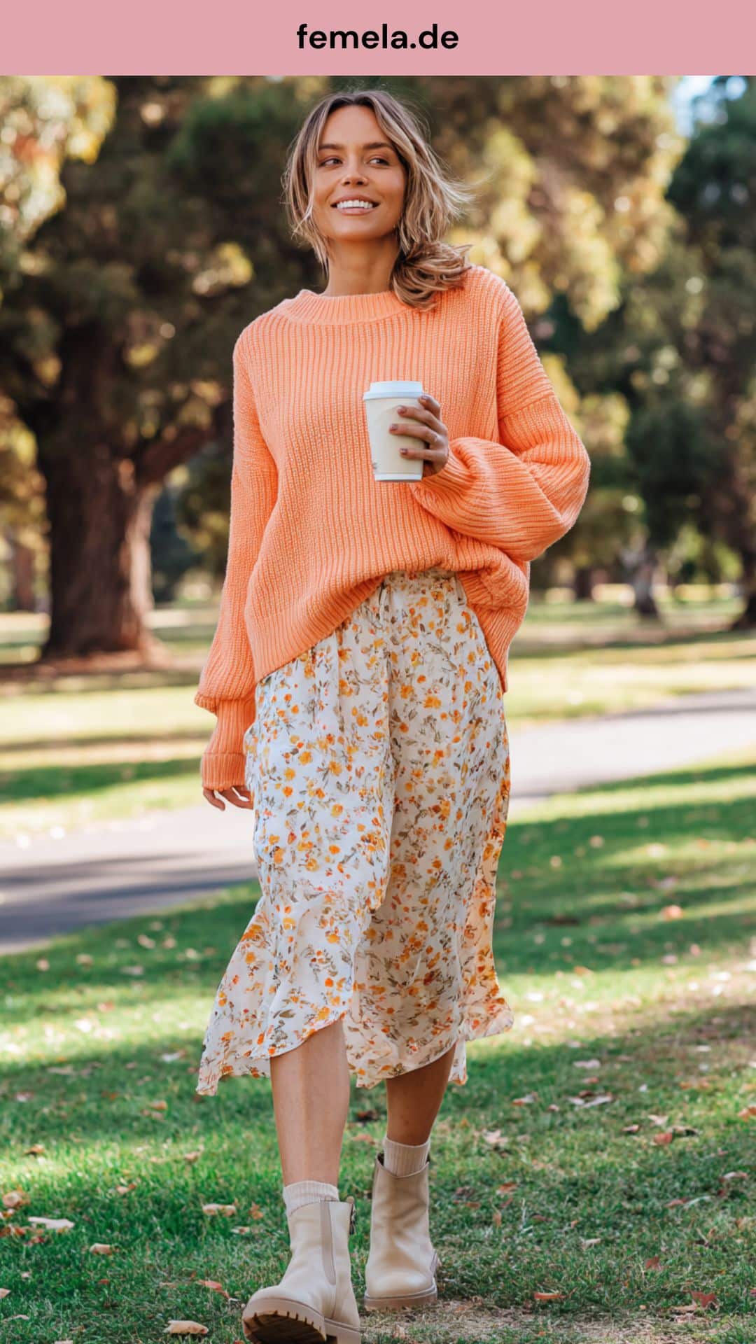 Kombination aus floralem Midirock und pfirsichfarbenem Strickpullover.