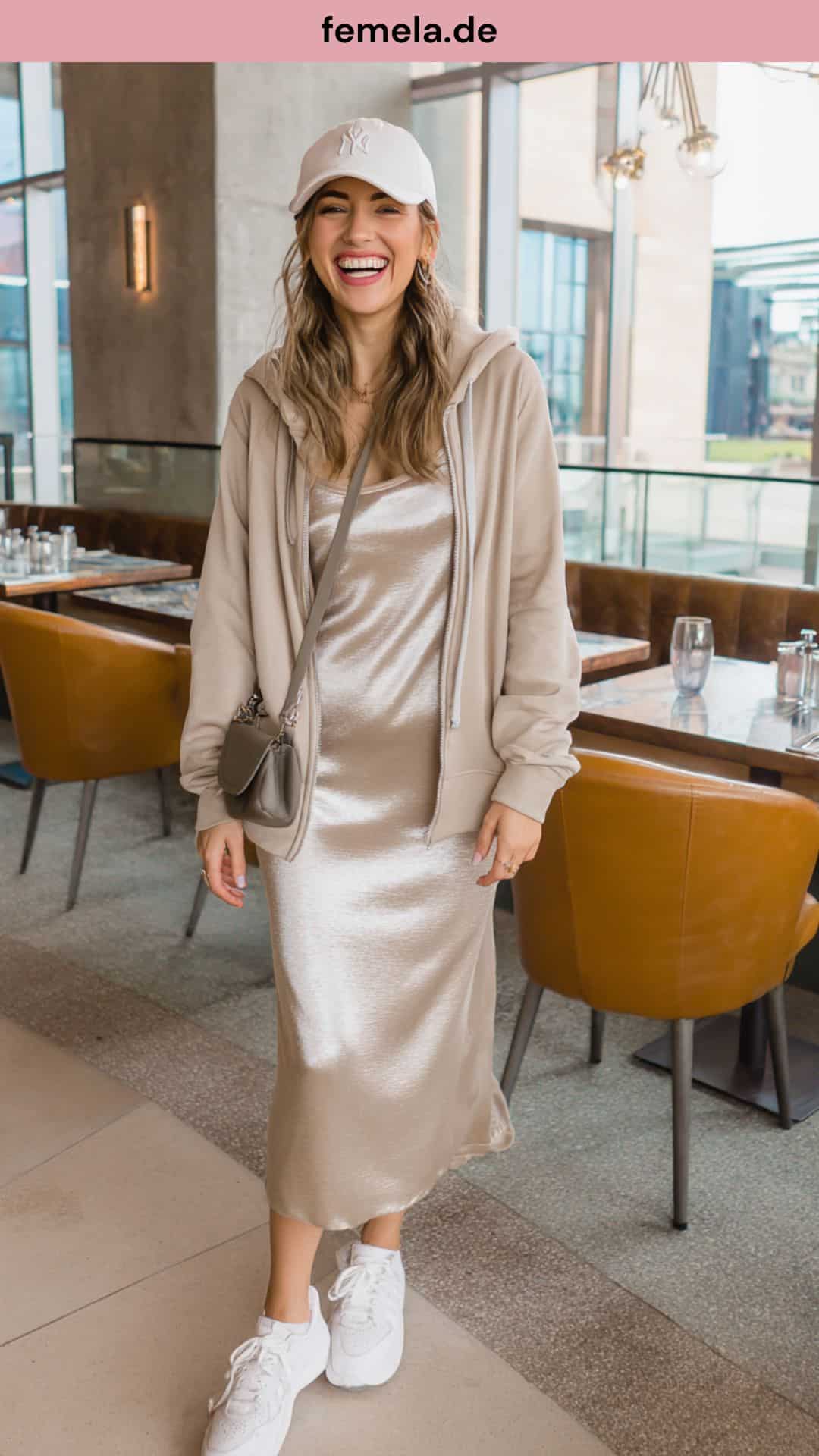 Lässiger Stilbruch: Satin-Kleid kombiniert mit Hoodie und Sneakern.