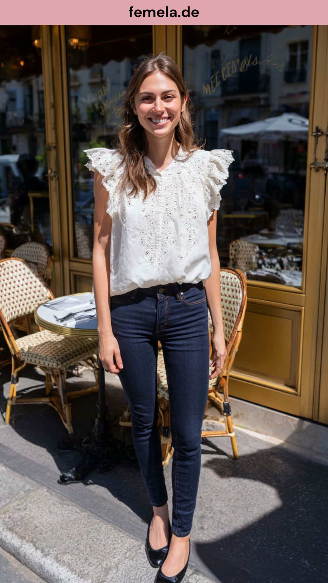 Weiblicher Look mit einer weißen Lochstickerei-Bluse, dunkler Jeans und schwarzen Ballerinas.