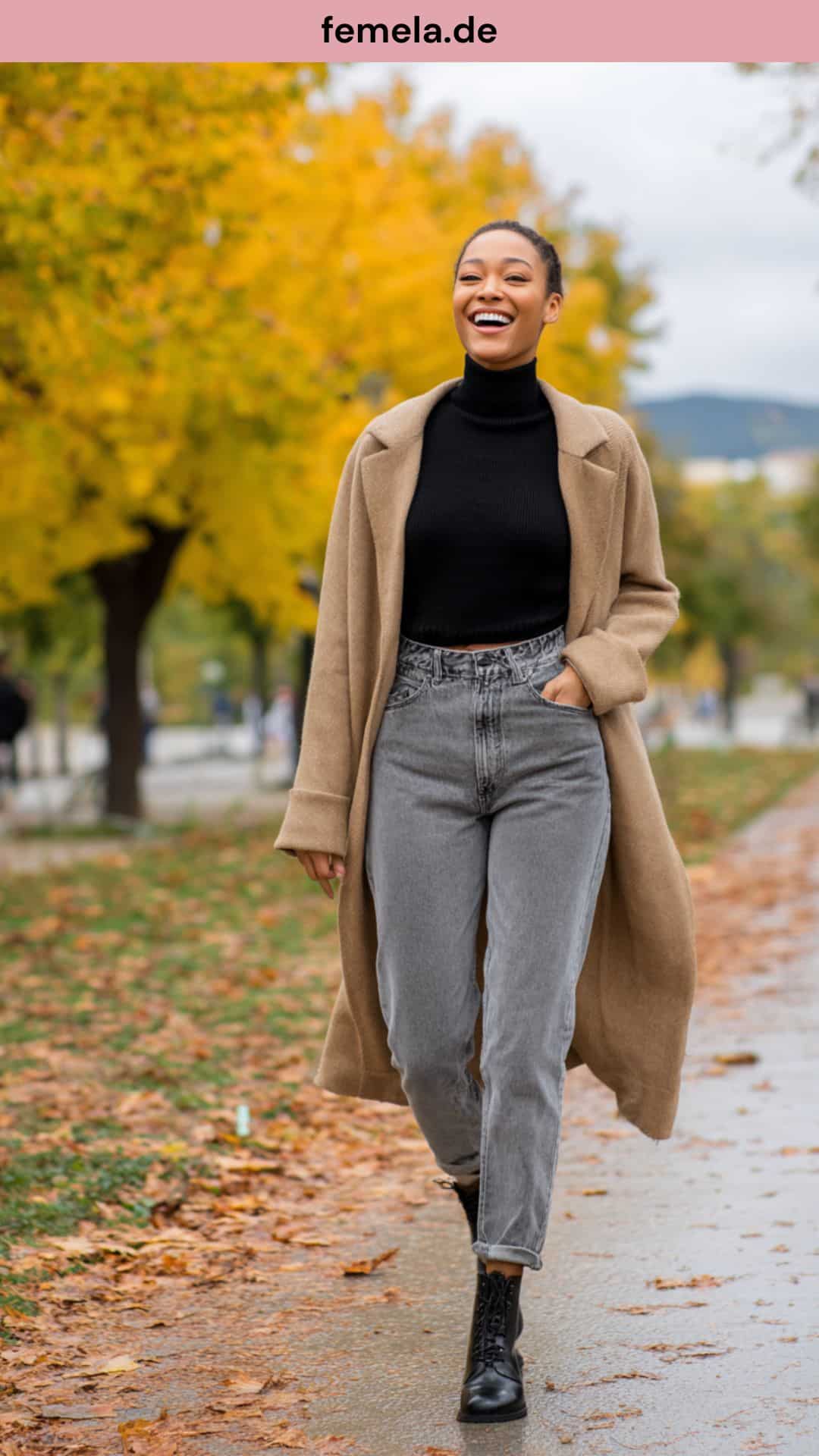 Herbstlicher Layering-Look mit grauer Mom-Jeans, schwarzem Rollkragenpullover und Camel-Mantel im Park.