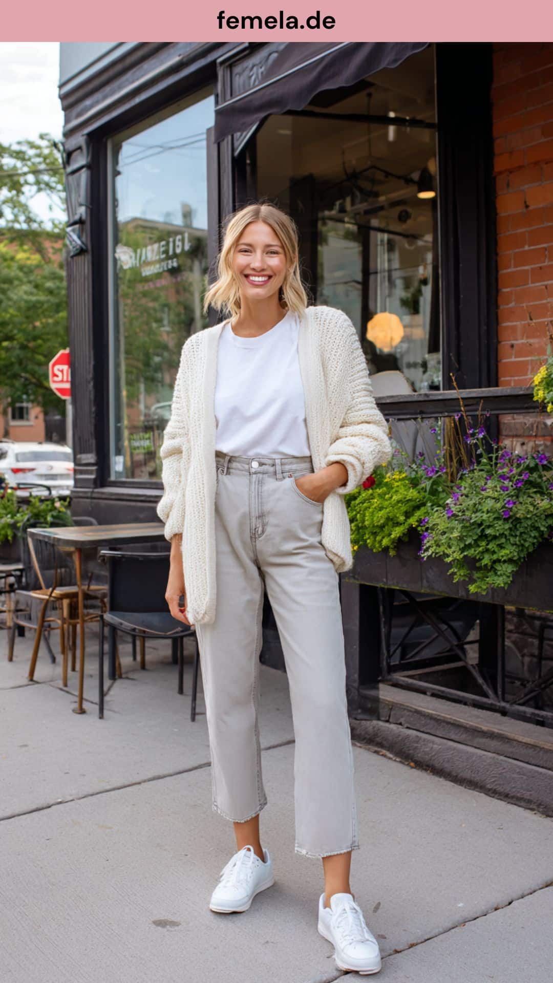 Alltags-Outfit mit hellgrauer Straight-Leg Jeans, weißem T-Shirt und hellbeigem Cardigan vor einem Cafe.