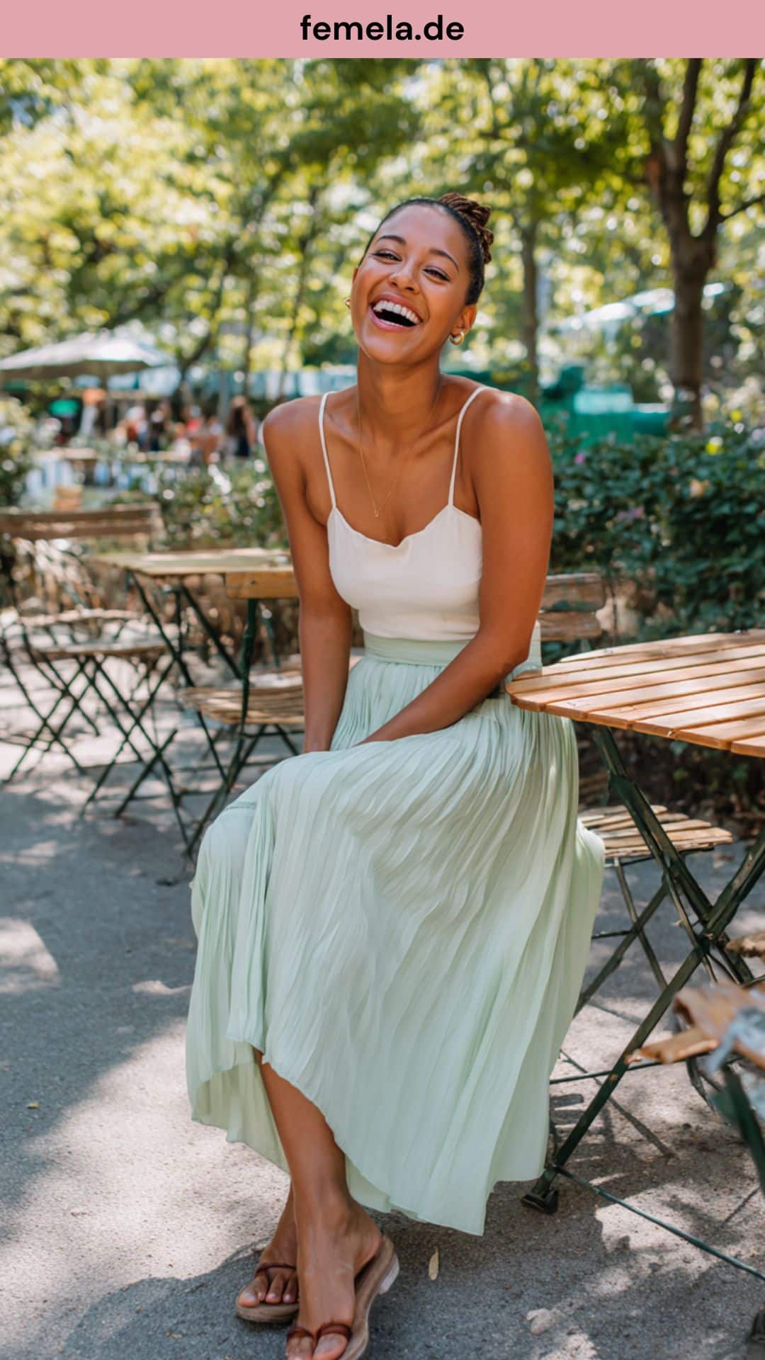 Sommerliches Plisseerock Outfit mit einem leichten Mint-grünen Rock, Seidentop und Sandalen im Café.