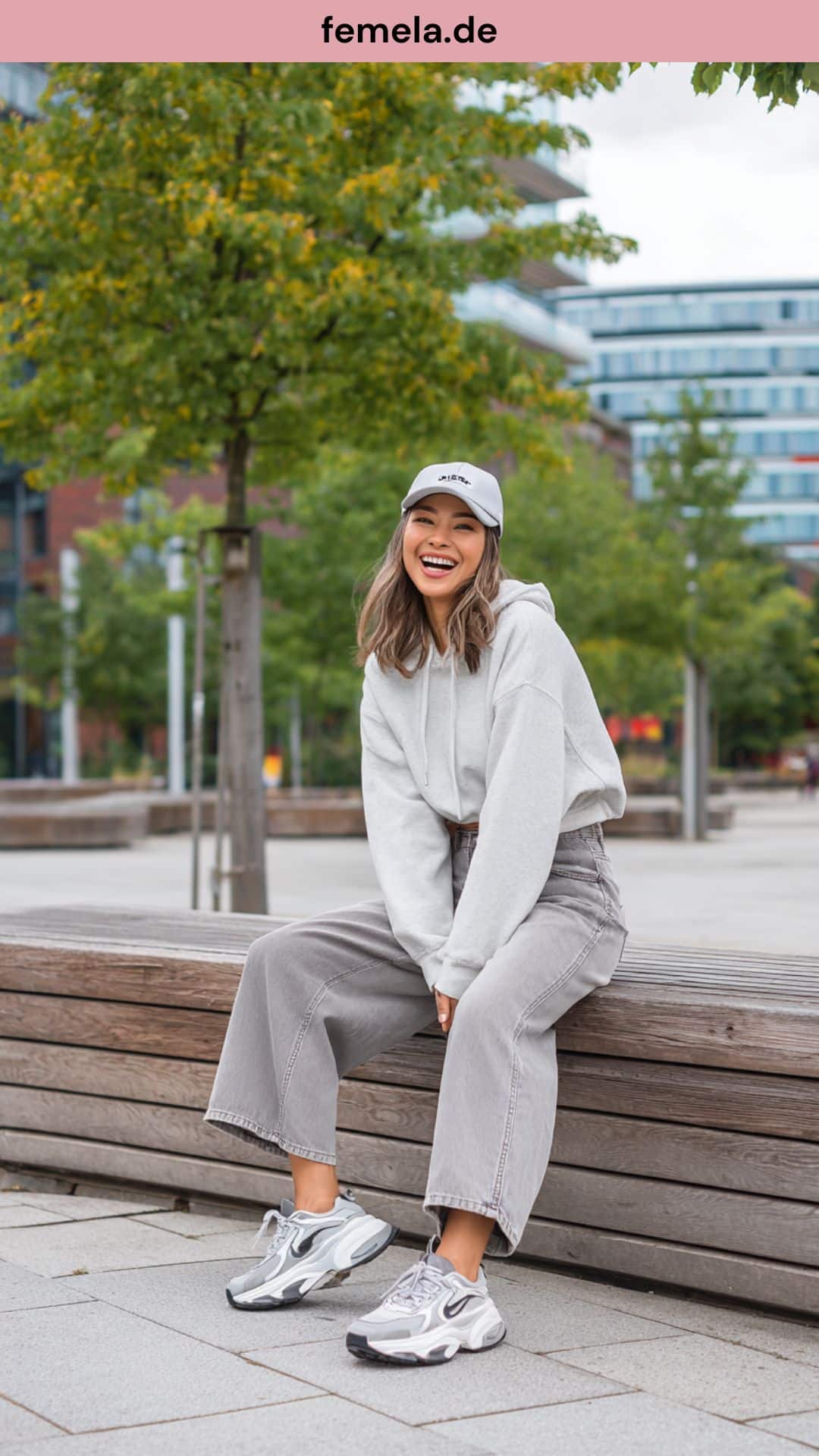 Bequemes Freizeit-Outfit mit weiter grauer Wide-Leg Jeans, grauem Hoodie und sportlichen Sneakers.